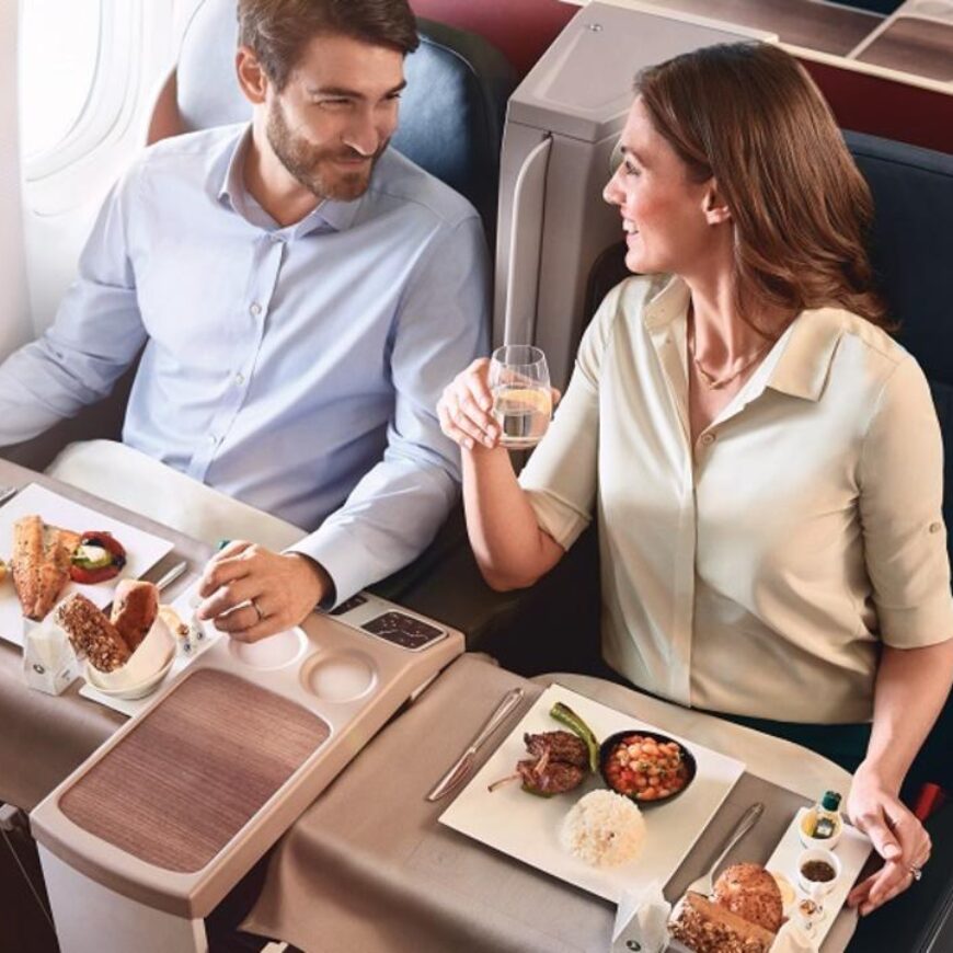 Two people on a Turkish airline flight enjoying a meal