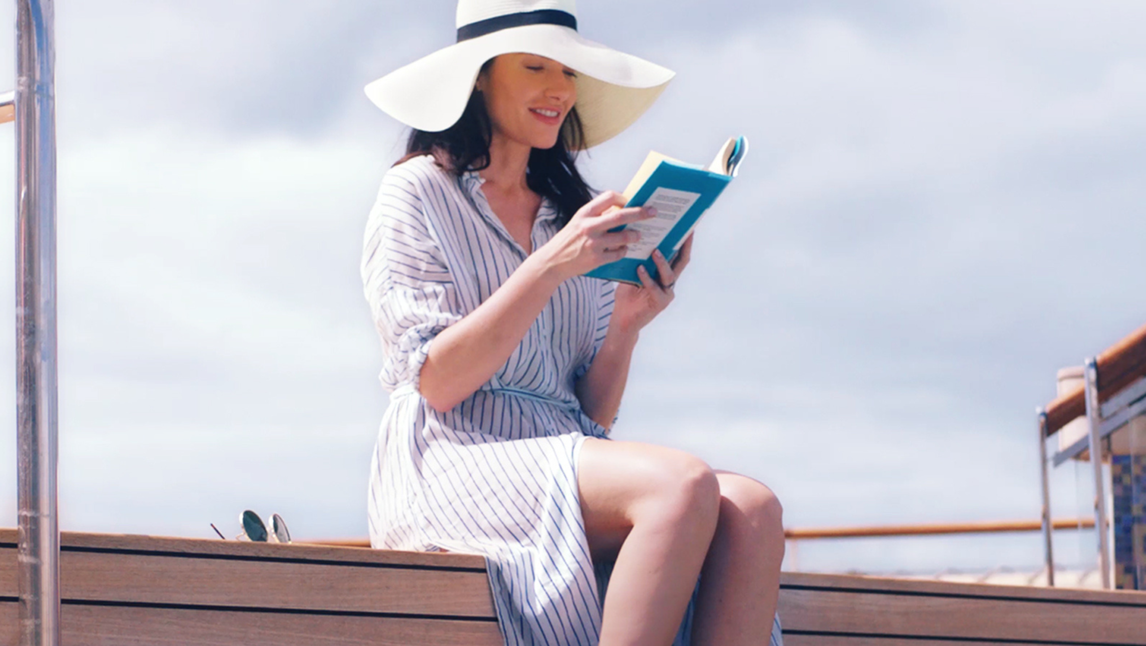 A woman reading a book onboard a Cunard ship